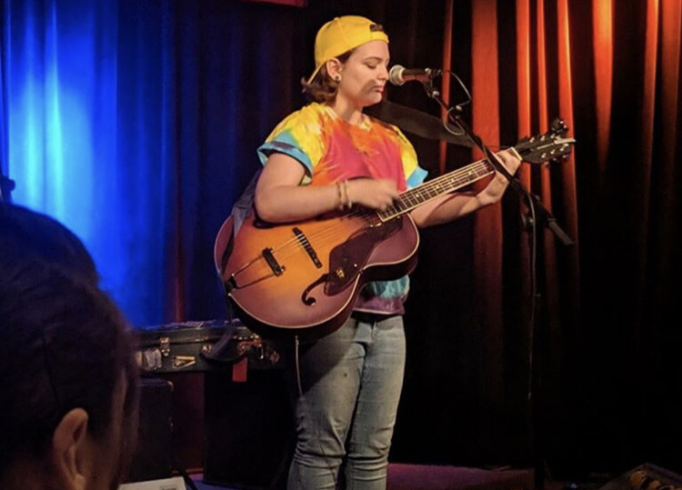 There is supposed to be a picture of Rona playing the guitar here, but for some reason it didn't show up.